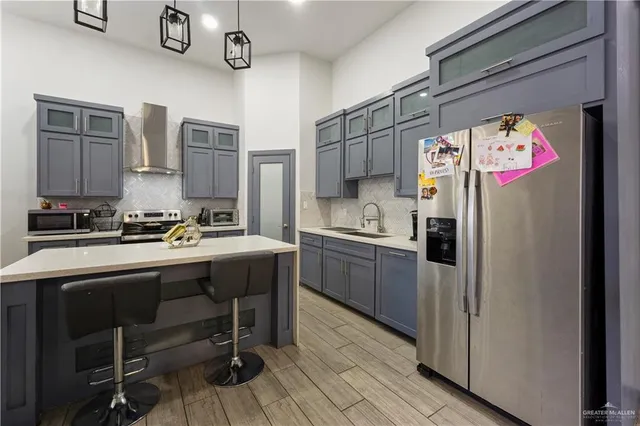 a kitchen with stainless steel appliances granite countertop a refrigerator and a stove top oven