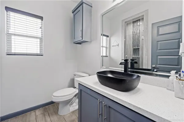 a bathroom with a toilet a sink and mirror