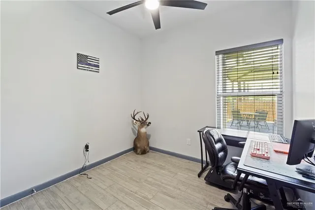 a view of a workspace with furniture and a window
