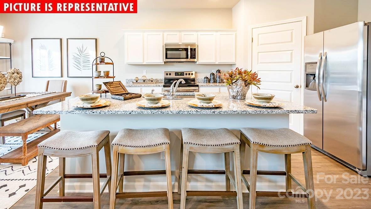 2147 Vanderlyn Street Monroe, NC 28112 - Photo 8 of 22 a kitchen with a sink and chairs