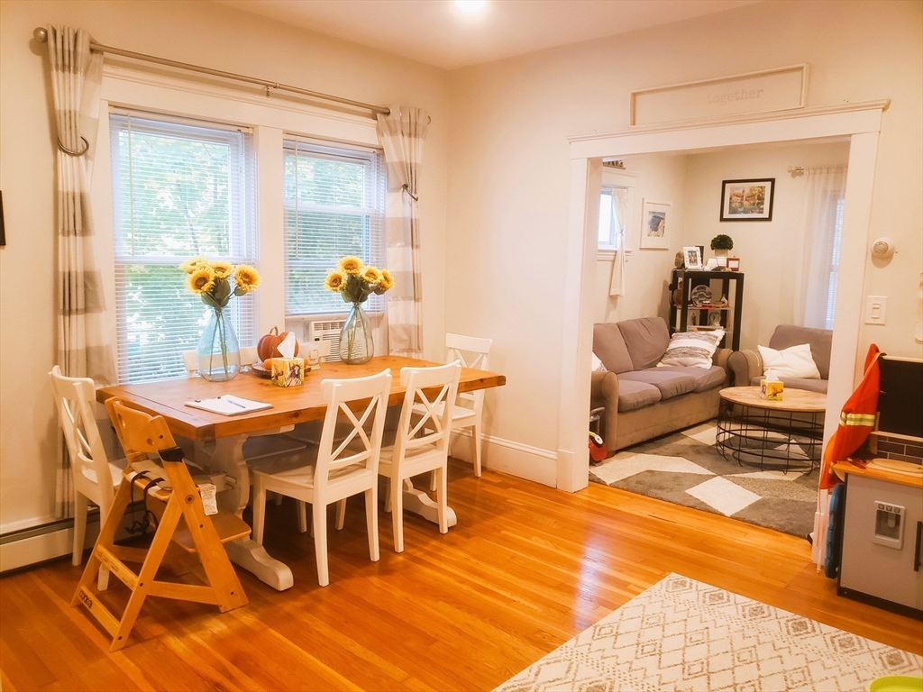 a dining room with furniture wooden floor and a rug