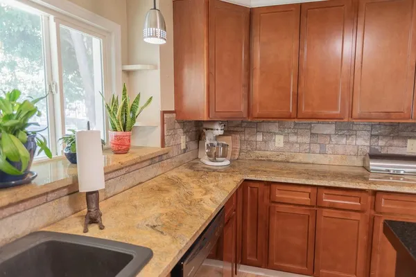 a kitchen with stainless steel appliances granite countertop a sink a counter space and cabinets