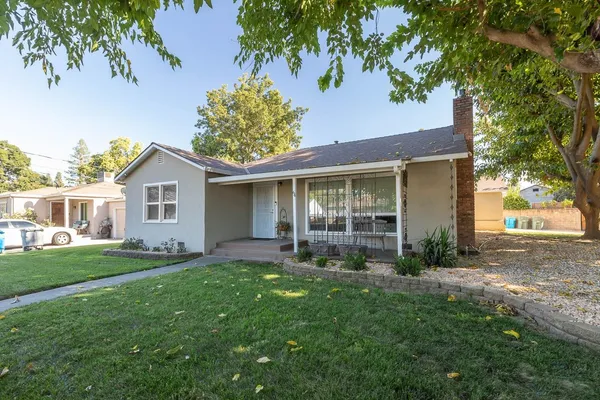 front view of a house with a yard and trees