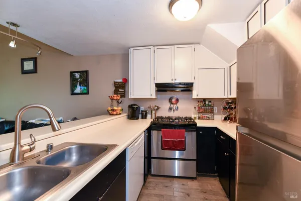 a kitchen with kitchen island granite countertop a sink stainless steel appliances and cabinets