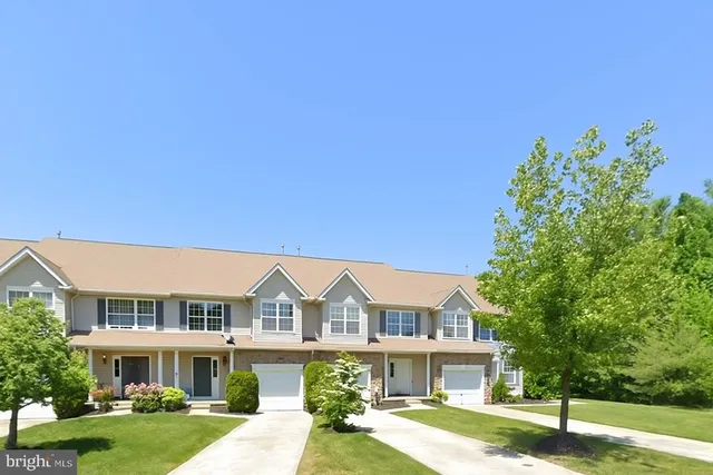a front view of a residential houses with yard and green space