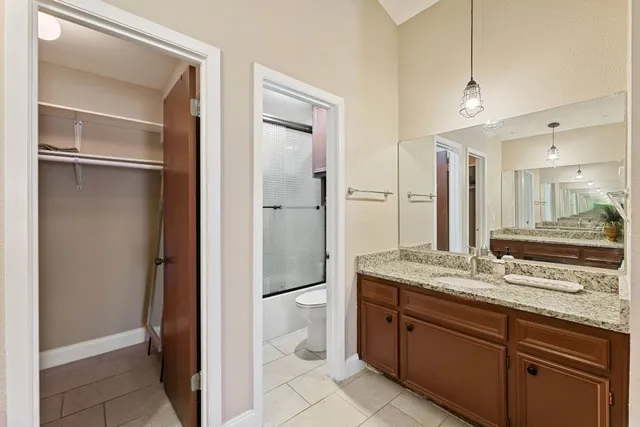 a spacious bathroom with a granite countertop sink and a mirror
