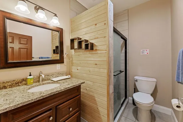 a bathroom with a granite countertop toilet sink and mirror