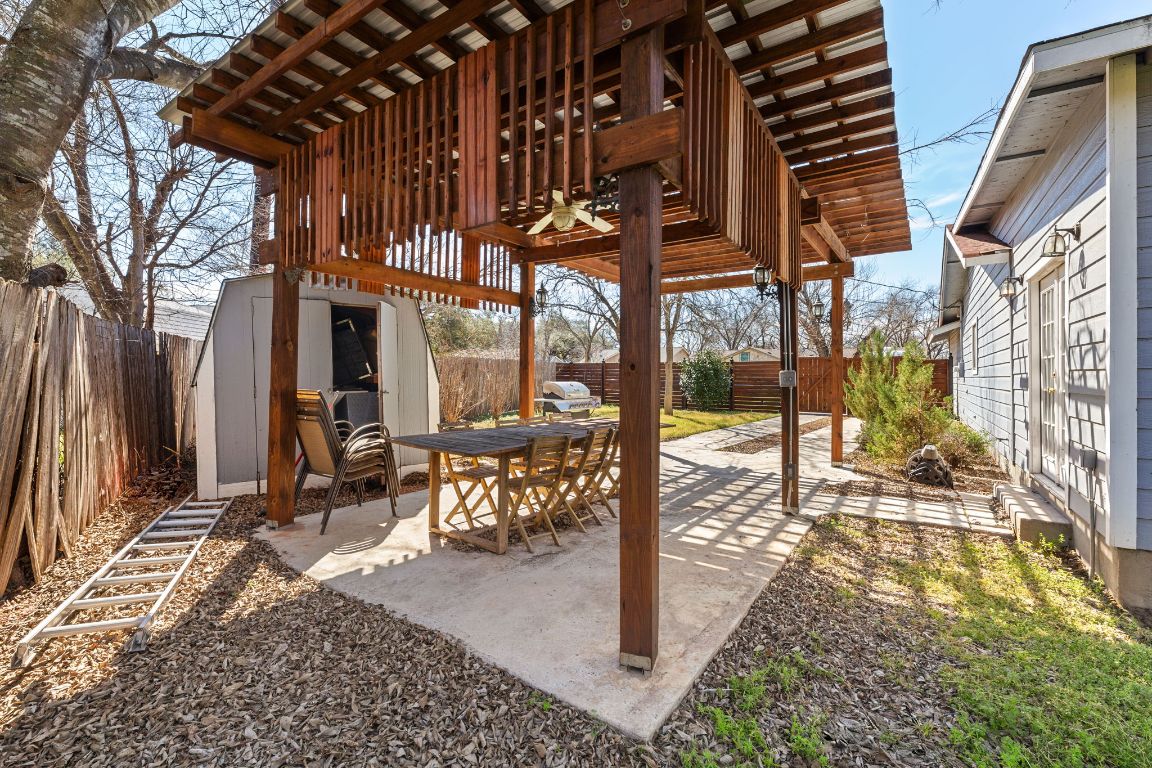 1602 Plateau Ridge Cedar Park, TX 78613 - Photo 24 of 29 a view of a patio with table and chairs and floor to ceiling window with wooden fence