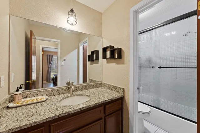 a bathroom with a granite countertop sink and a mirror