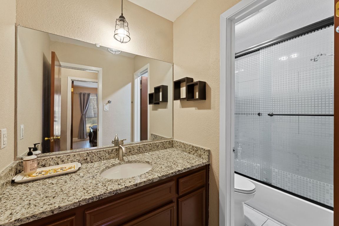 1602 Plateau Ridge Cedar Park, TX 78613 - Photo 10 of 29 a bathroom with a granite countertop sink and a mirror