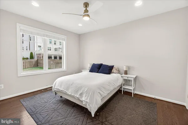a view of a hallway with wooden floor and a living room