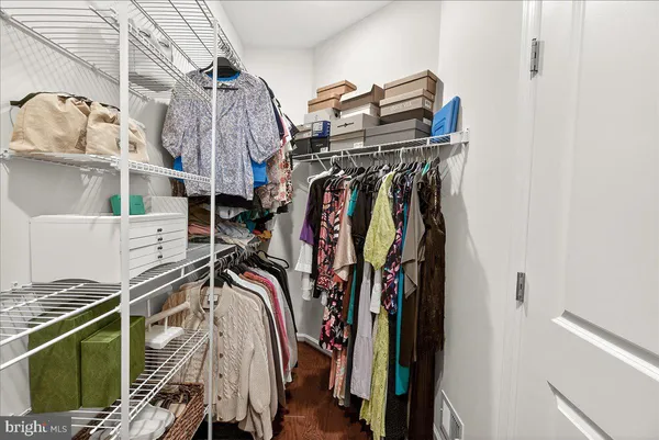 a view of walk in closet with clothes and shoes