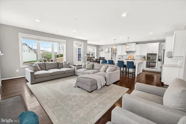 a living room with furniture and view of kitchen