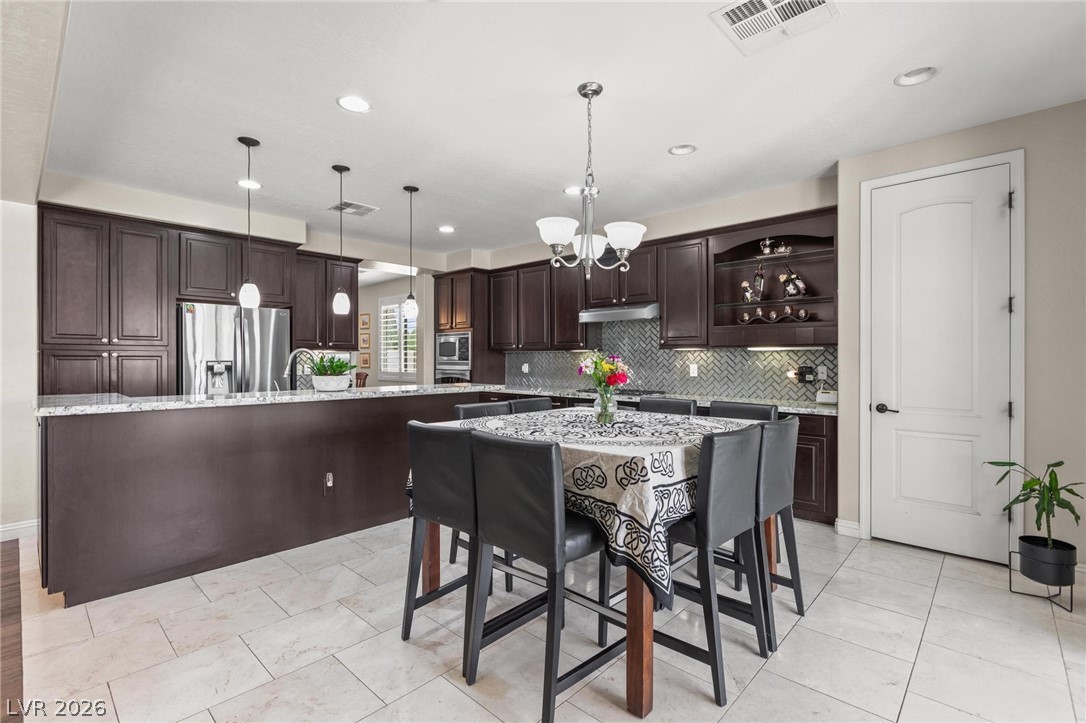 8431 Durango Ranch Court Las Vegas, NV 89113 - Photo 11 of 49 This spacious kitchen features ample cabinetry, modern appliances, and a convenient breakfast bar for casual dining.