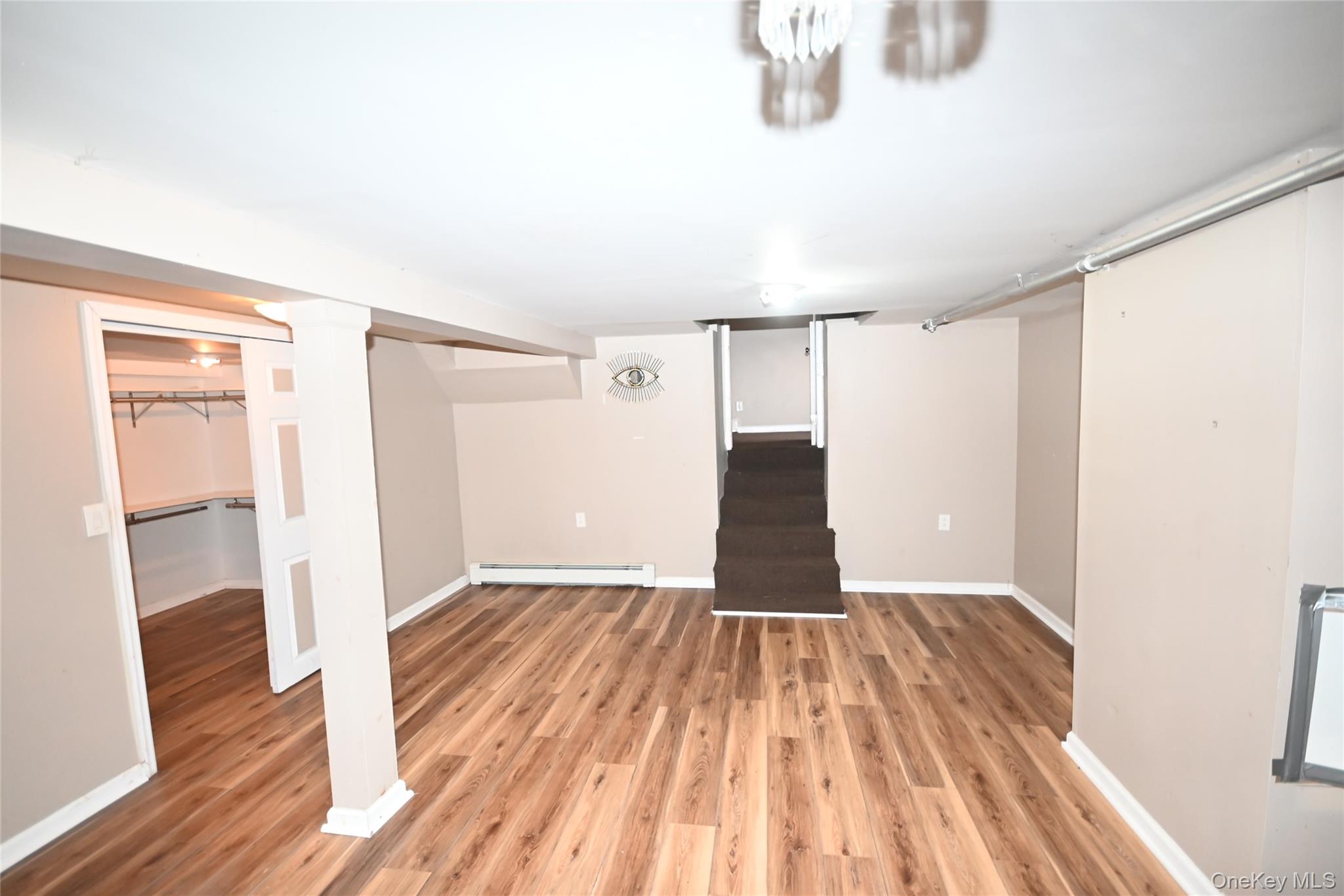89 Osborne Road West Hempstead, NY 11552 - Photo 45 of 50 Finished basement featuring stairway, light wood finished floors, and baseboard heating