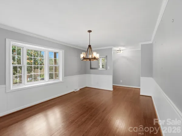 a view of a room with wooden floor chandelier and a ceiling fan