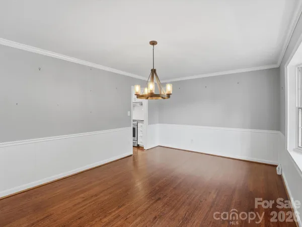 a kitchen with stainless steel appliances granite countertop a stove top oven a sink and white cabinets with wooden floor