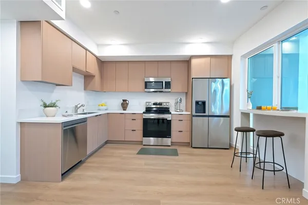 a kitchen with a refrigerator a sink and a stove top oven