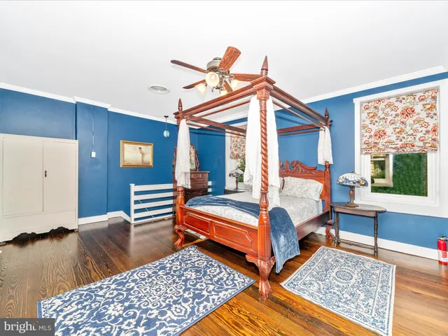 a bedroom with a bed and a bookshelf with wooden floor