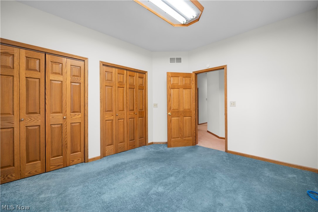 51488 Peck Wadsworth Road Wellington, OH 44090 - Photo 38 of 50 Room featuring blue carpeting, white walls, and wood-finish trim