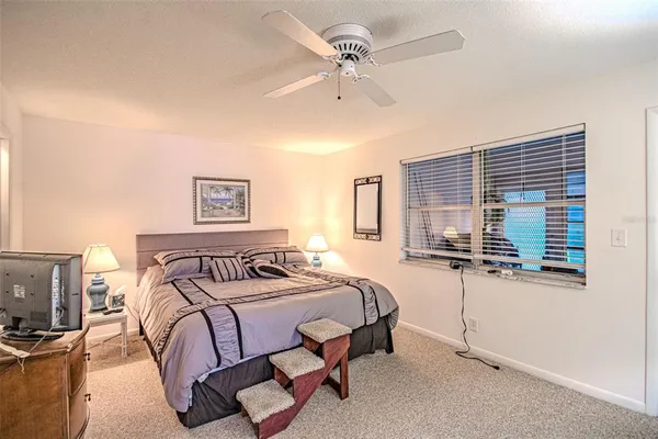 a bedroom with a bed dresser and window