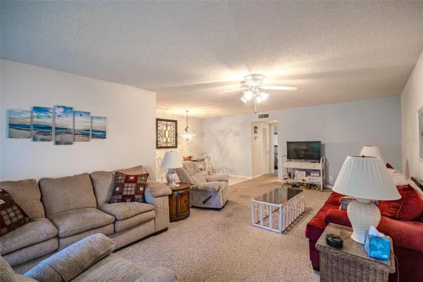 a living room with furniture a lamp and a flat screen tv