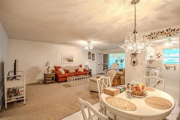a living room with furniture a chandelier and a dining table