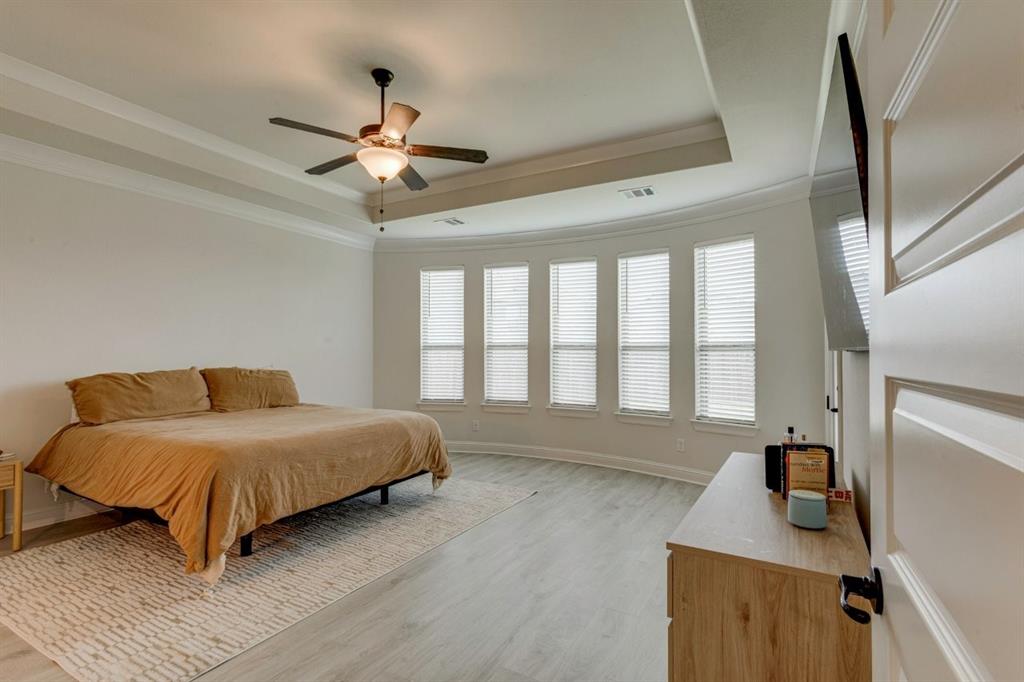9613 Boulder Pt Road Oak Point, TX 75068 - Photo 18 of 28 Spacious room featuring light wood-finish flooring, a tray ceiling with crown molding, and a ceiling fan