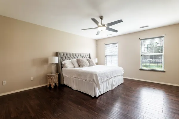 a bedroom with a bed and wooden floor