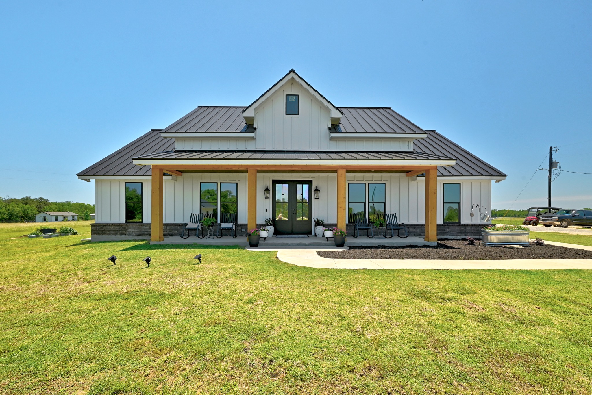 2889 Old McMahan Road Lockhart, TX 78644 - Photo 1 of 33 A welcoming front porch with natural wood pillars offers a charming entry to this modern farmhouse.
