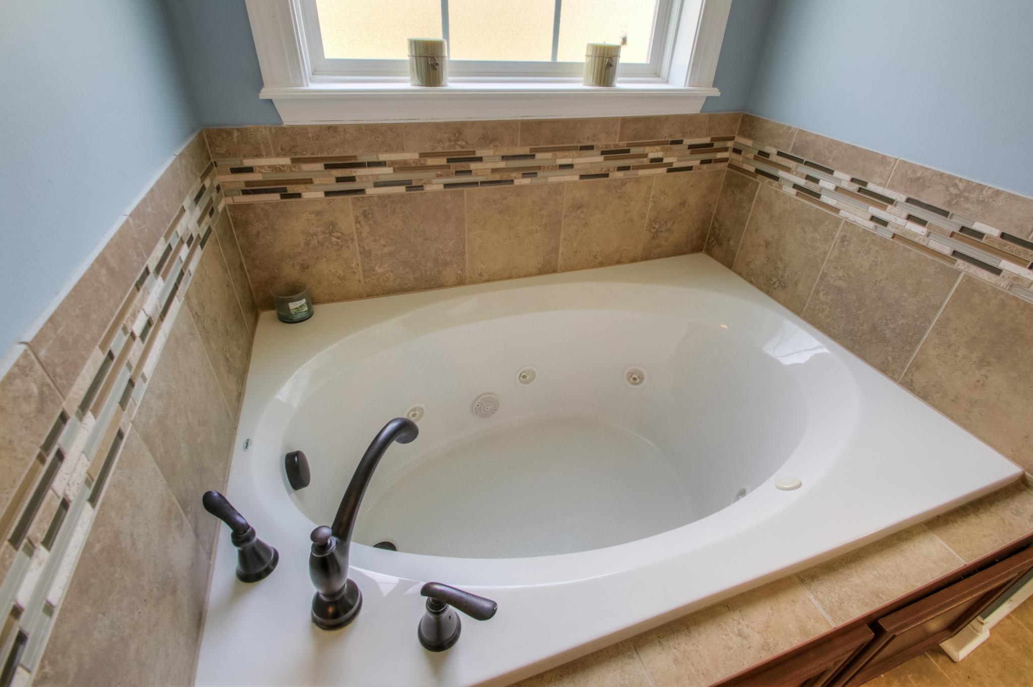7675 Knobdate Road Smyrna, TN 37167 - Photo 18 of 26 A whirlpool tub with this custom tile is typical of the extra attention to high end finishes in this home.