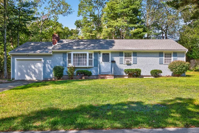 a view of a house with a yard and potted plants