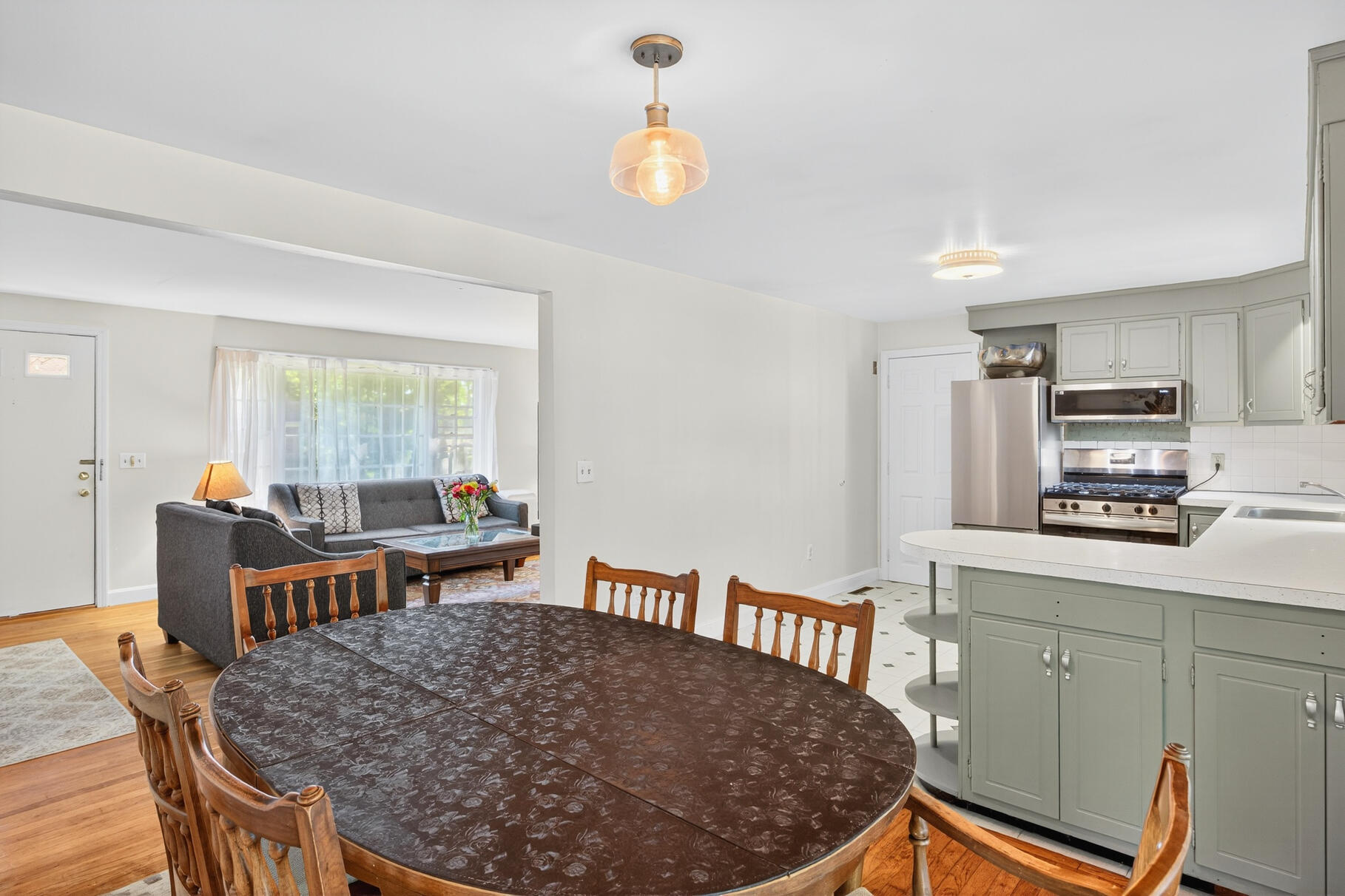 101 Longfellow Drive Centerville, MA 02632 - Photo 10 of 27 a kitchen with stainless steel appliances granite countertop a stove top oven a sink a dining table and chairs with wooden floor