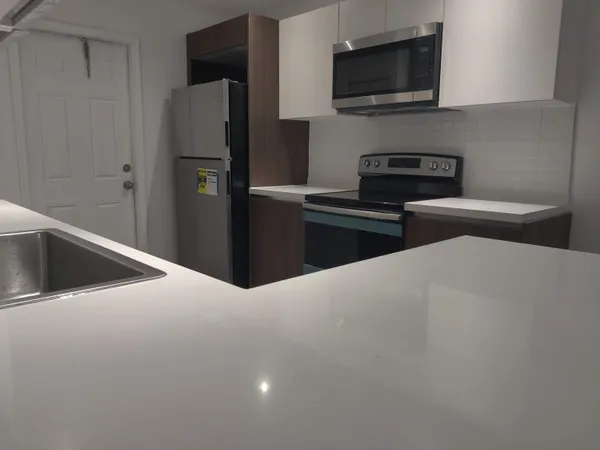 a kitchen with a refrigerator and a stove top oven