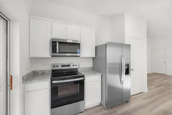 a kitchen with a refrigerator stove and microwave
