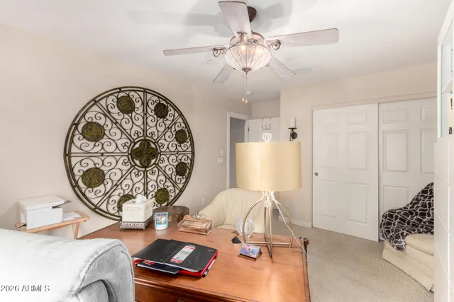 a view of a patio with a table and chairs under an umbrella with a small yard