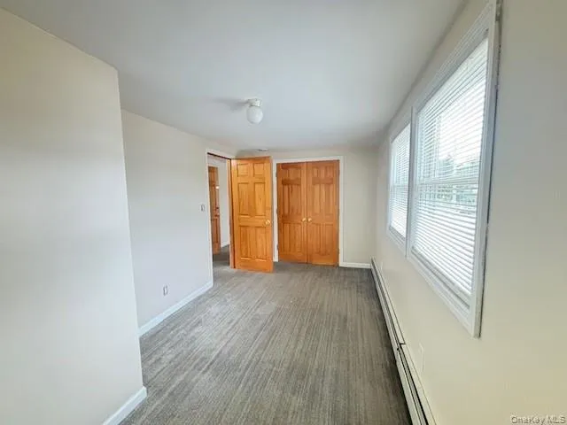 an empty room with windows and closet