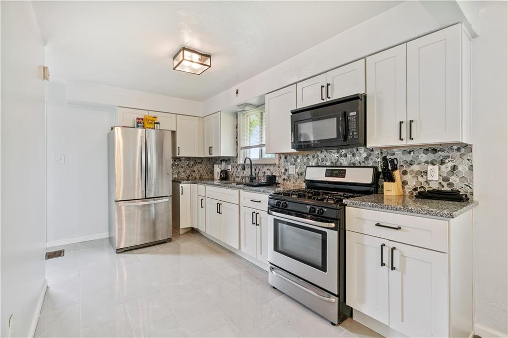 2429 Perry Street Munhall, PA 15120 - Photo 5 of 23 a kitchen with stainless steel appliances granite countertop a refrigerator stove a sink and a microwave