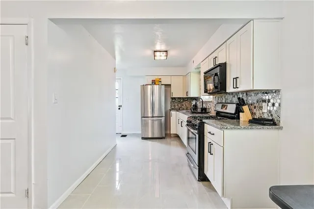 a kitchen with stainless steel appliances a refrigerator a stove top oven a sink and dishwasher