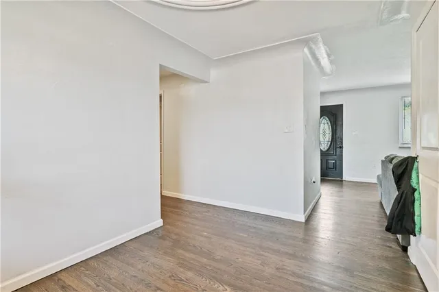 a view of a hallway with wooden floor and closet