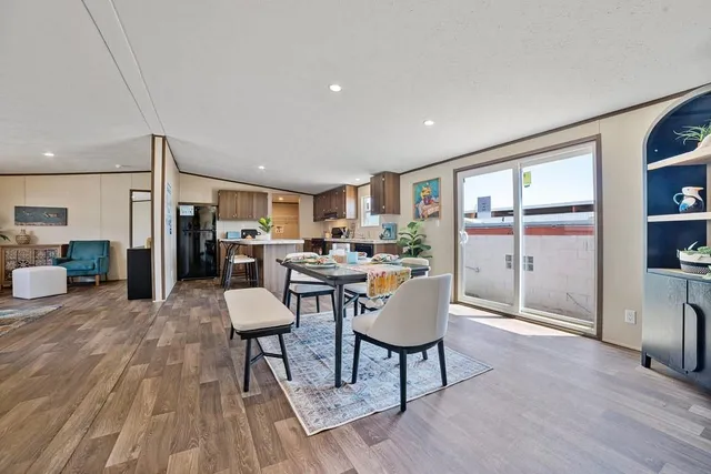 a living room with furniture a table and kitchen view