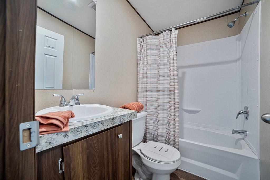 284 Pine Grove Road Gordonville, TX 76245 - Photo 24 of 29 a bathroom with a sink toilet vanity and shower