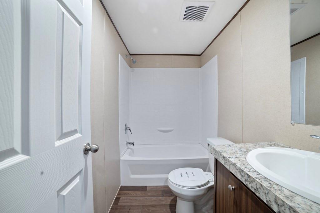 284 Pine Grove Road Gordonville, TX 76245 - Photo 27 of 29 a bathroom with a granite countertop toilet sink and mirror