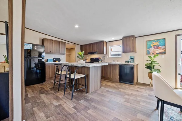 a kitchen with a table chairs refrigerator and a counter top space