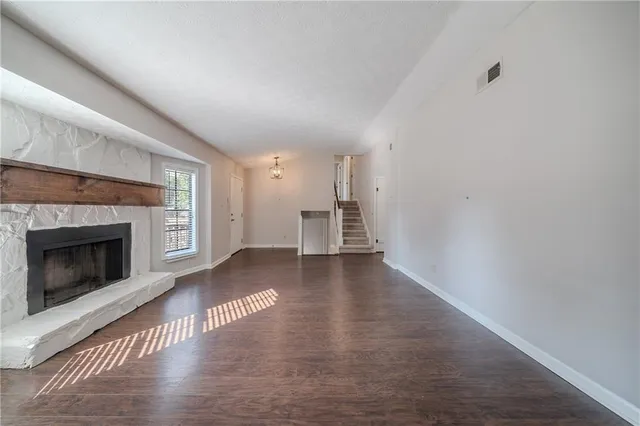 a view of a livingroom with wooden floor and a fireplace