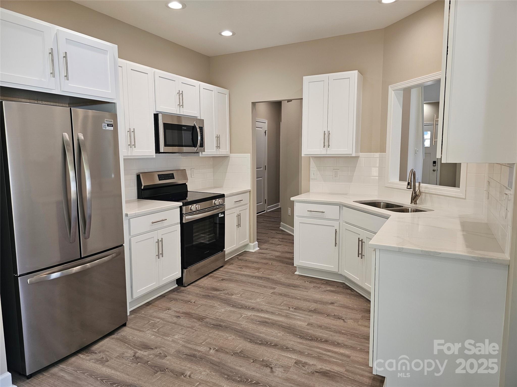 3679 Travertine Drive Lancaster, SC 29720 - Photo 6 of 26 a kitchen with white cabinets and stainless steel appliances