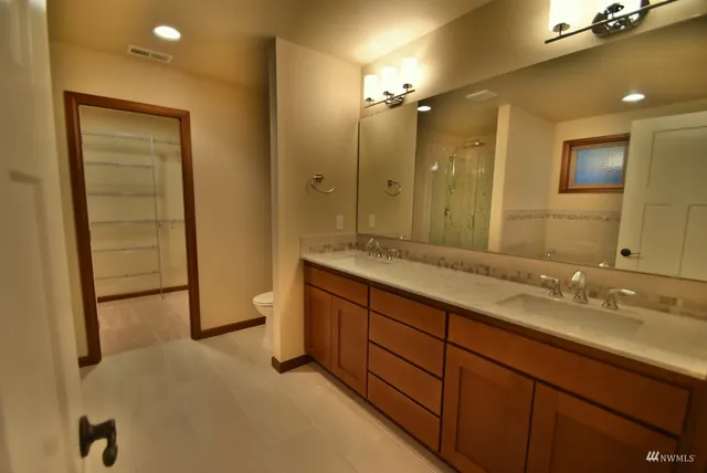 a spacious bathroom with a granite countertop sink mirror and shower