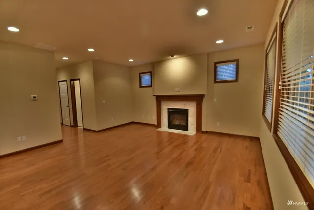 a view of empty room with wooden floor and fireplace