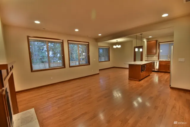 a view of a big room with wooden floor and windows
