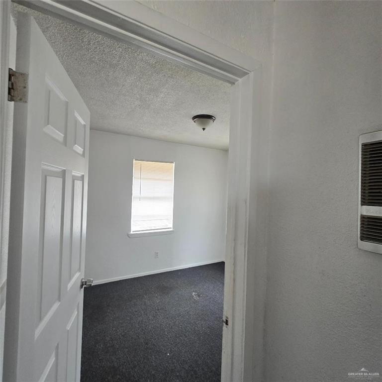 306 East Roberts Avenue Donna, TX 78537 - Photo 6 of 8 Unfurnished room featuring dark carpet and a textured ceiling